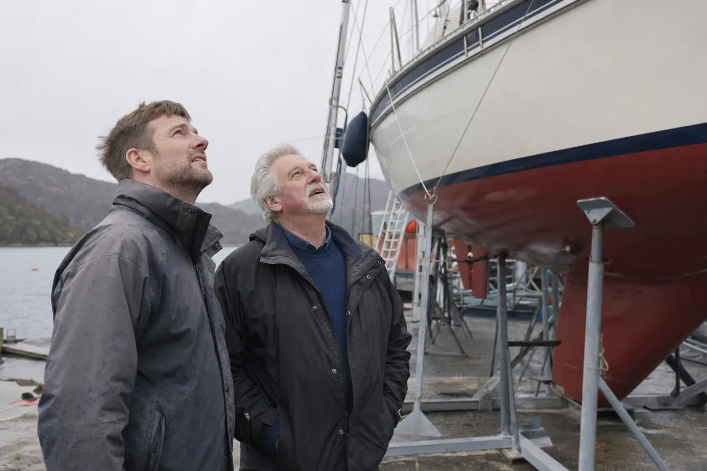 A broker and an owner going over a cruising yacht's rig at a boatyard